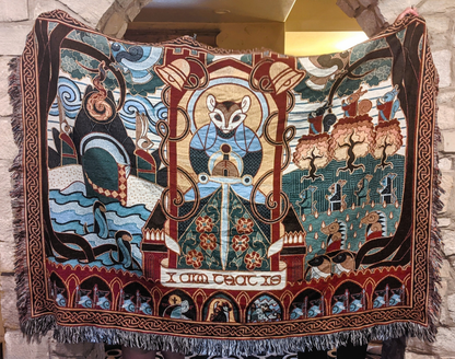 Decorative tapestry with intricate designs and characters, hanging against a stone wall.